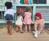 a group of children playing on a wooden bench